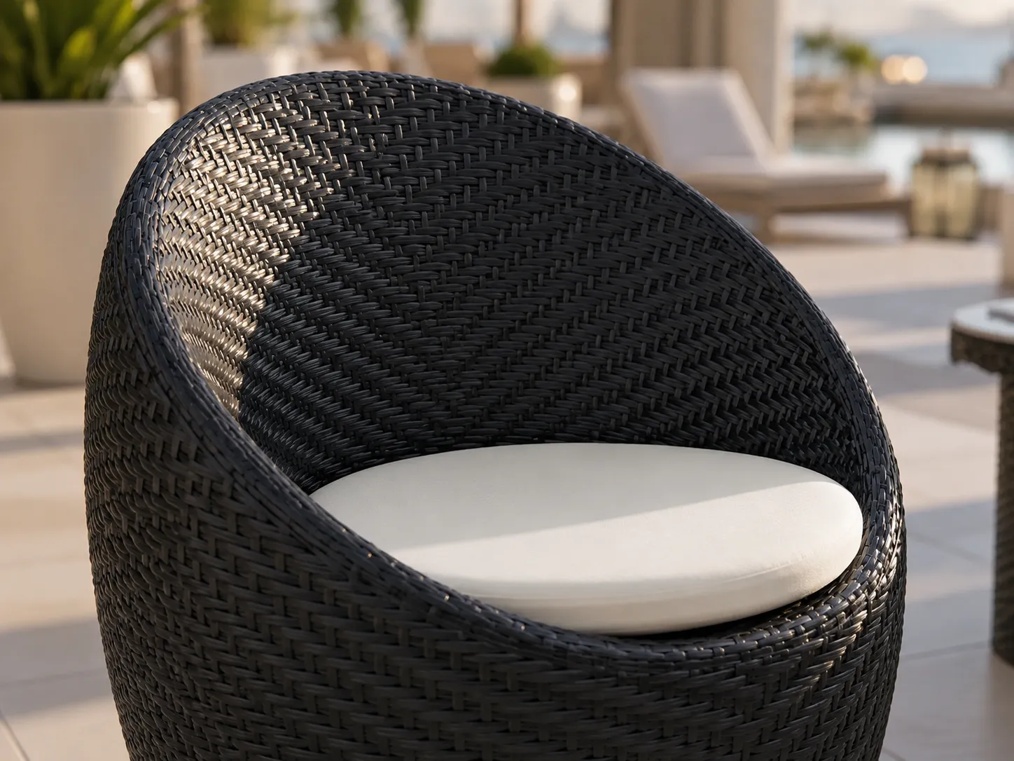 Black PE rattan barrel chair detail with cream cushion