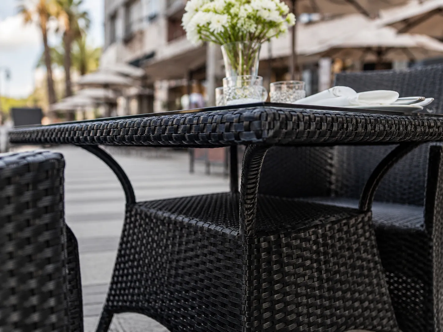 Black wicker outdoor dining armchair detail with PE rattan weave