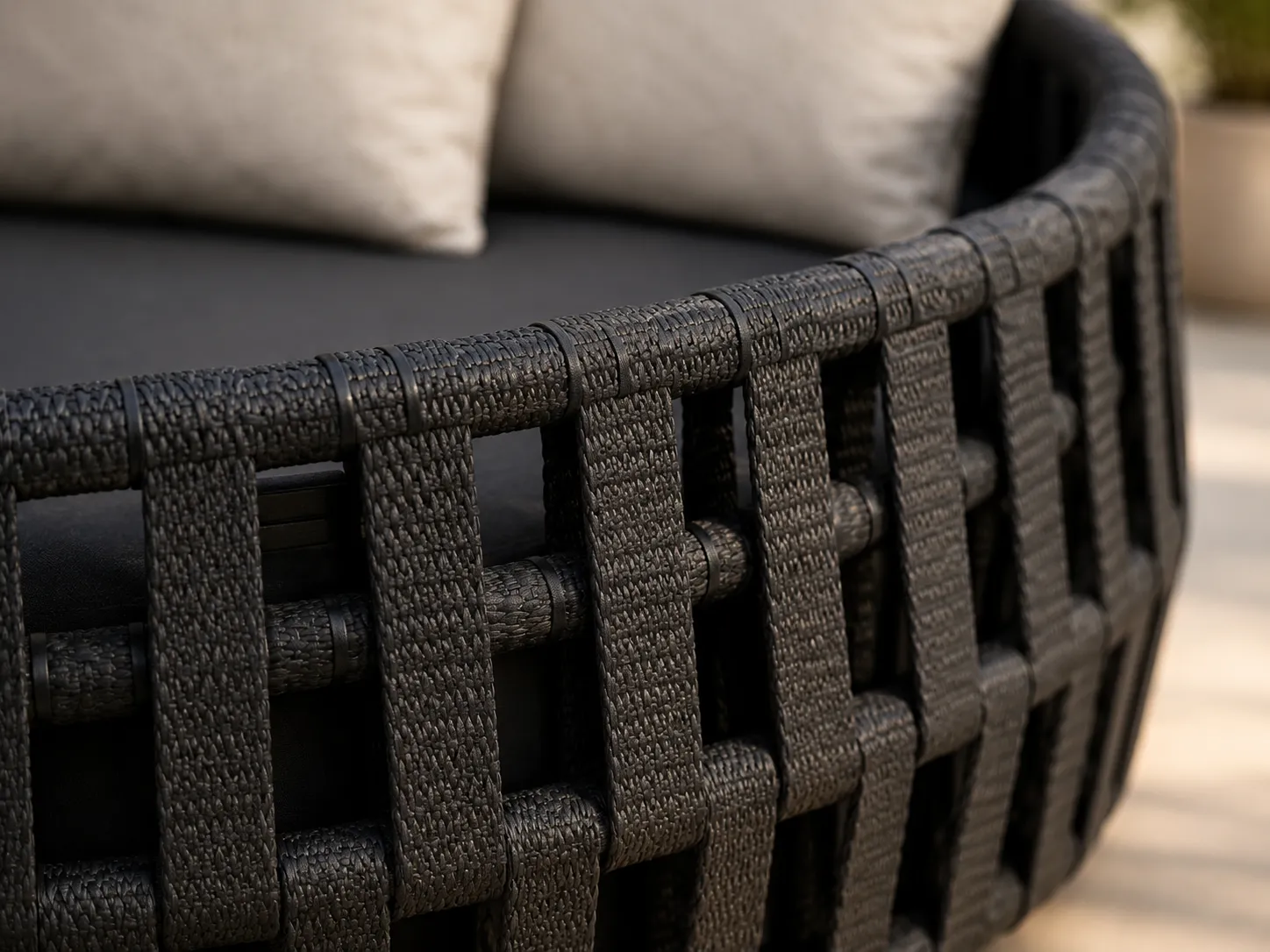 Close-up detail of black woven wicker frame for outdoor daybed