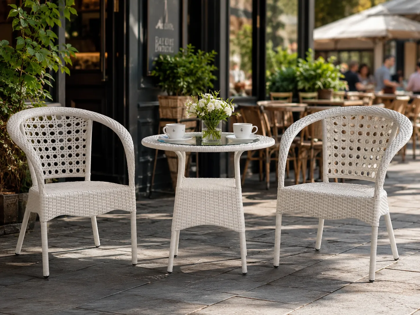 White rattan bistro set with round glass table for café terrace