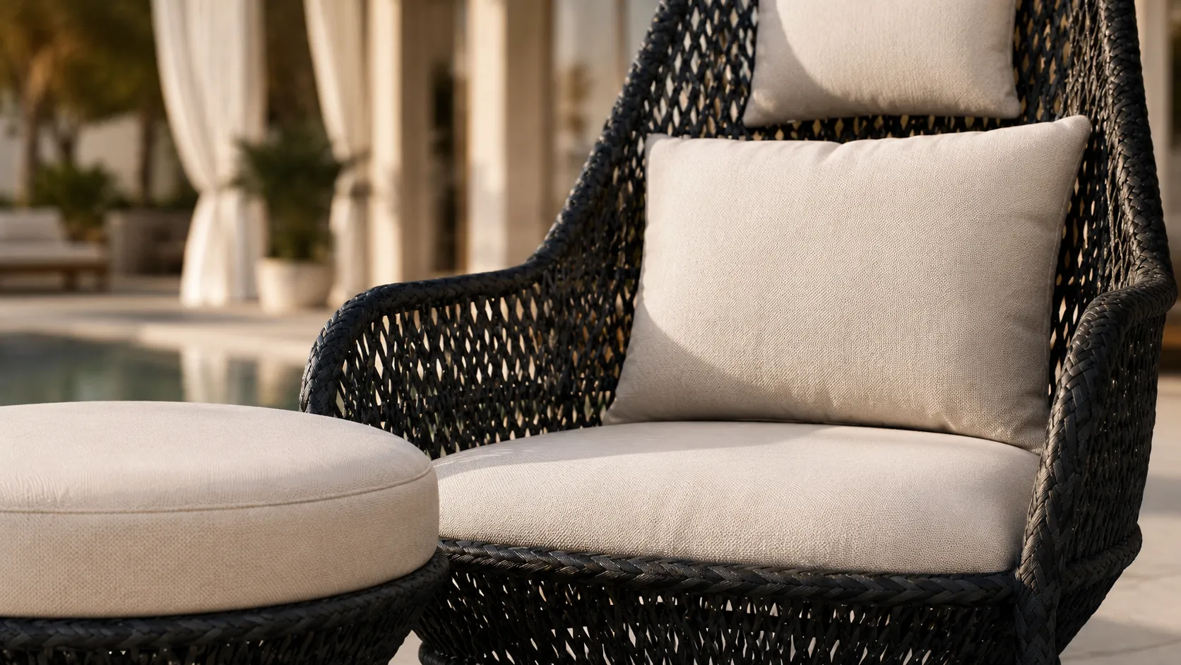 Cream cushion and ottoman detail of black wicker outdoor lounge chair set