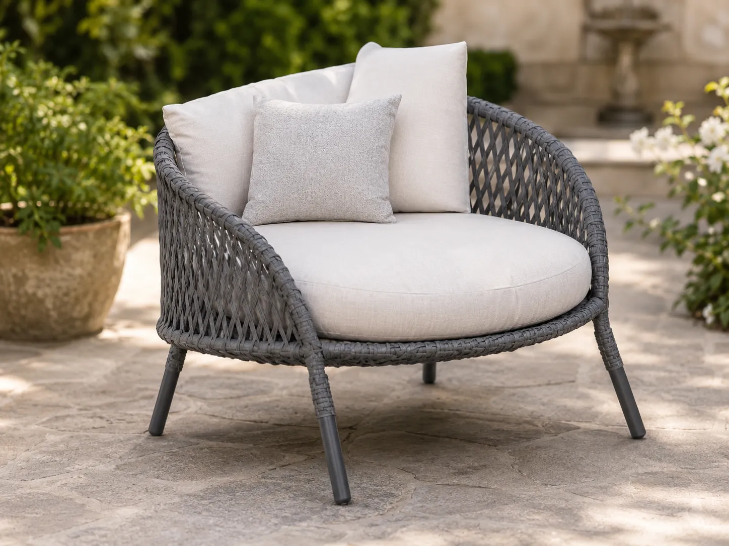 Grey wicker lounge chair detail with cream cushion and woven frame