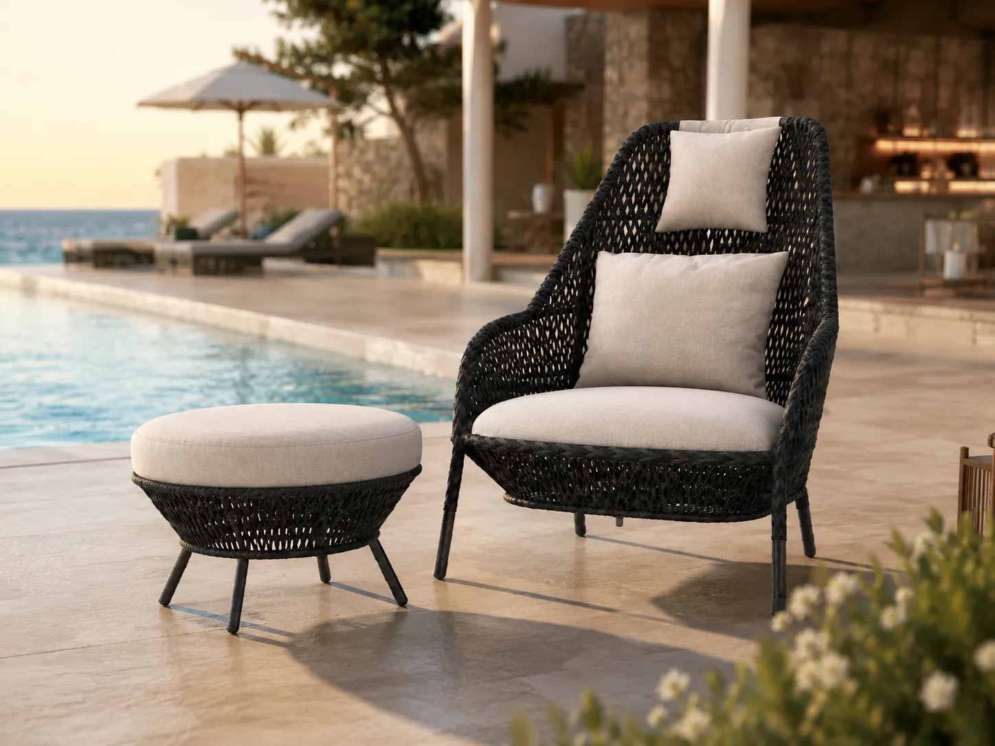 Black wicker lounge chair and ottoman used beside a hotel swimming pool