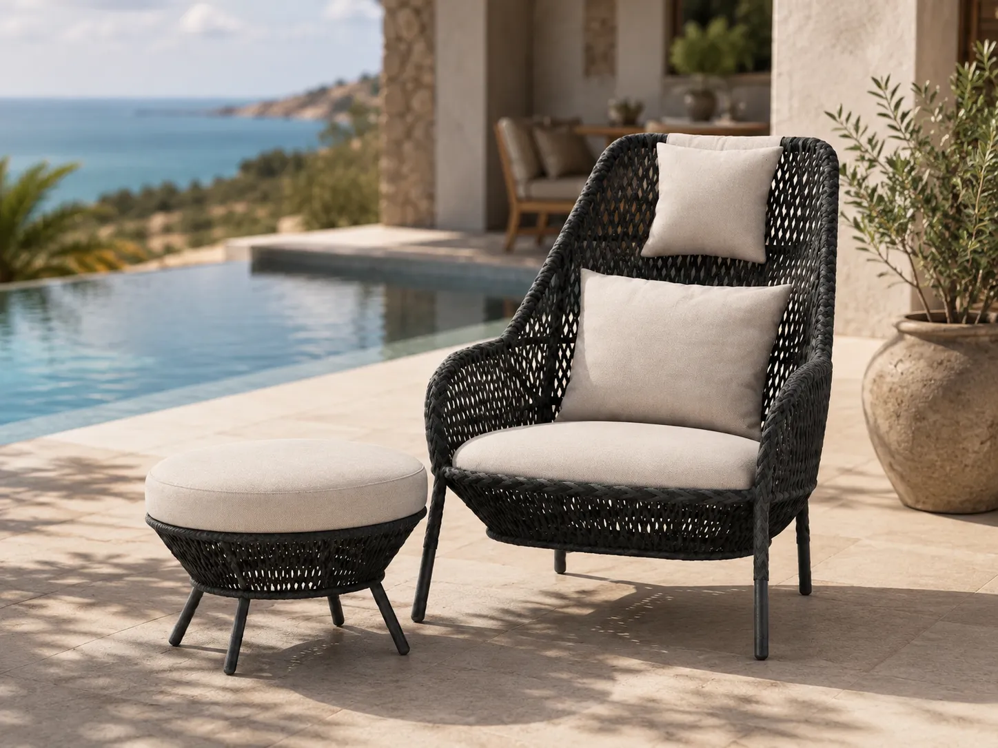 Black wicker outdoor lounge chair and ottoman for resort terrace relaxation spaces