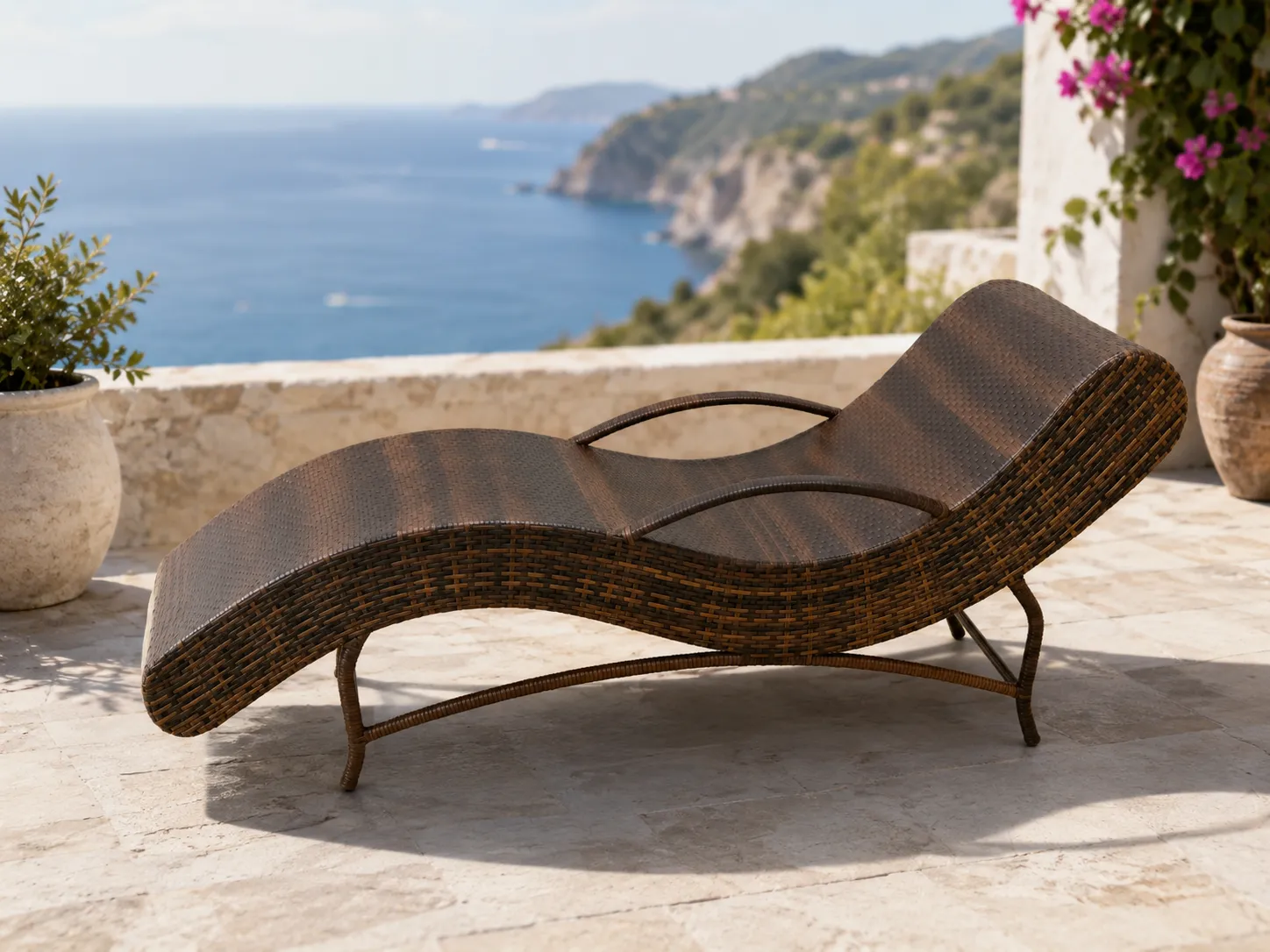 Wicker sun lounger with stainless steel frame on a sea-view terrace