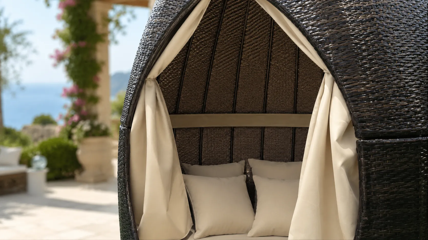 Wicker outdoor daybed with privacy curtains and soft cushions
